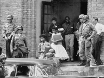 Чернокожие дети выходят из школы в Литл-Роке под охраной десантников